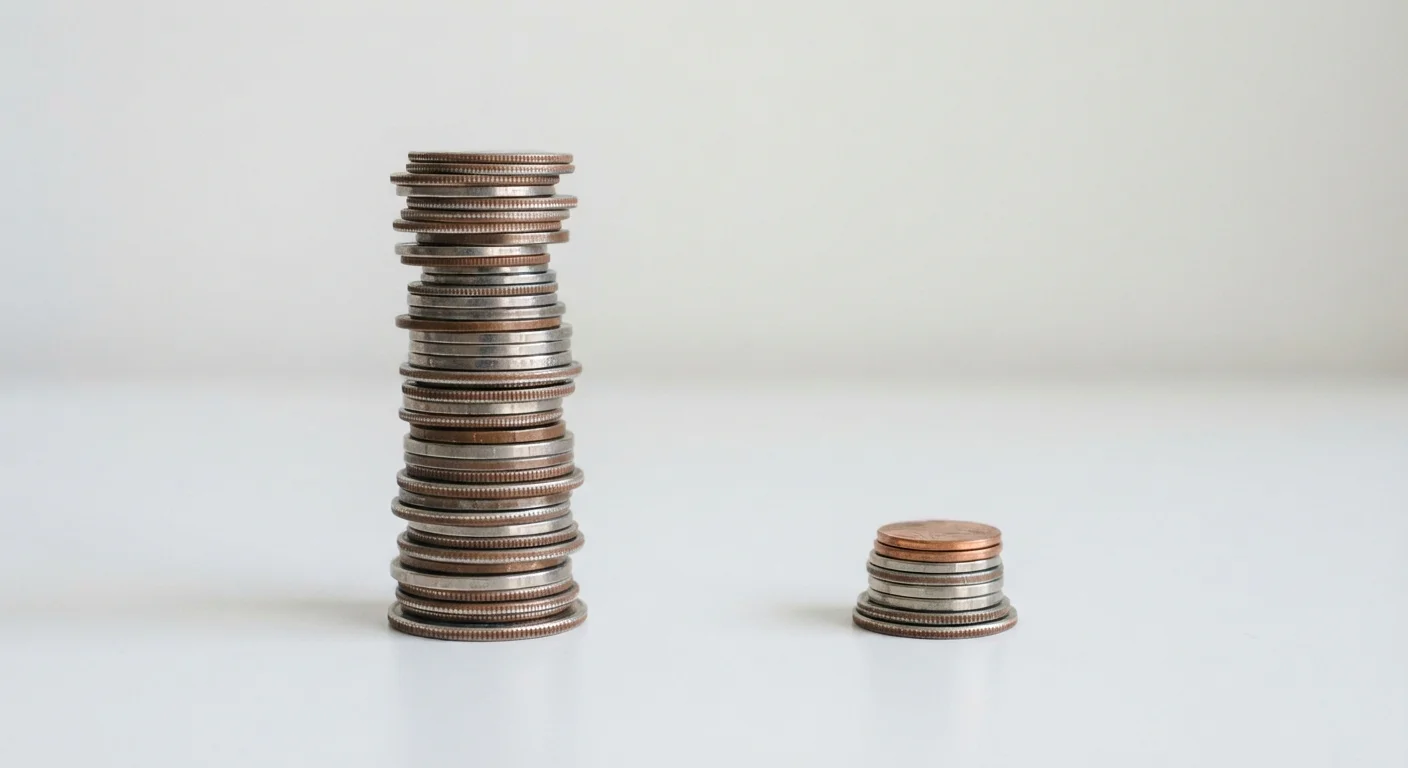 Two stacks of coins of different heights on a white surface, illustrating debt balances of different sizes.